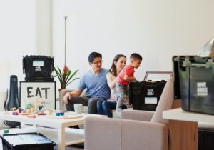 An image of a family in the living room packing up storage totes and boxes.